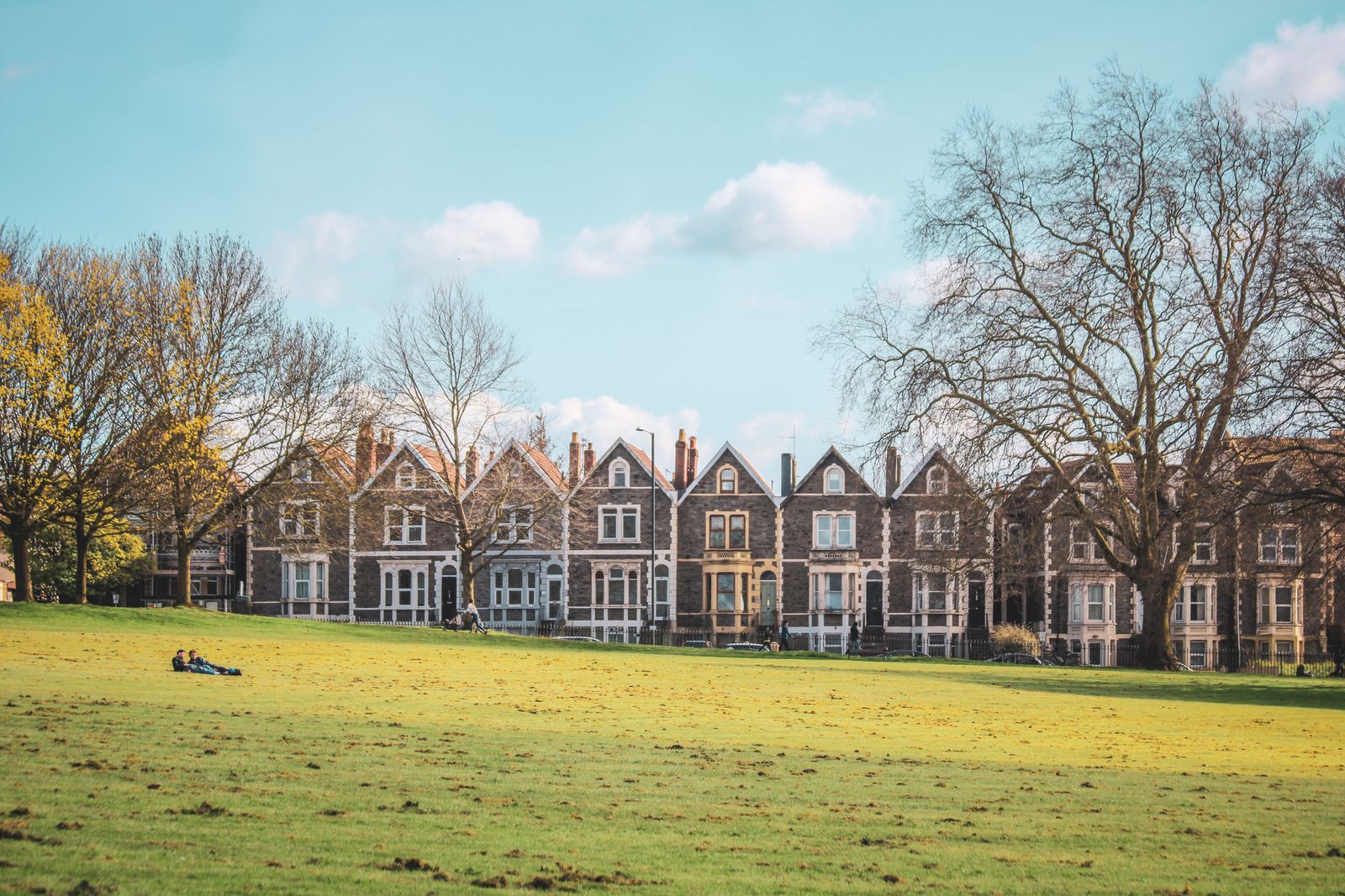 A terrace of Victorian homes beside a park.